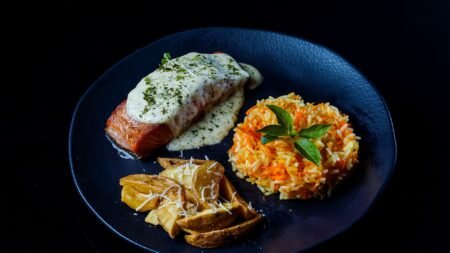 gourmet salmon dish with rice and wedges